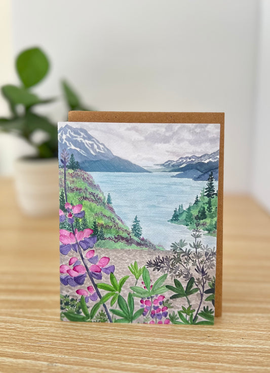 A2 card depicting Alaska's mountain scape in the background and lupine in the foreground. 