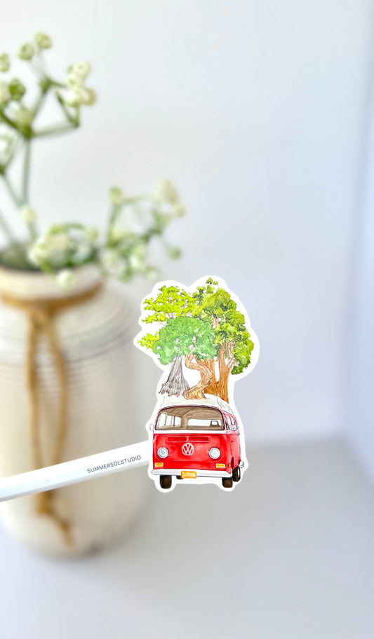 Red retro camper van with larger that life tree on top.